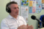 Man speaking into microphone with headphones
