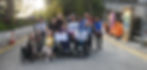 Diverse group, two in wheelchairs, holding Step-Away Association banners.